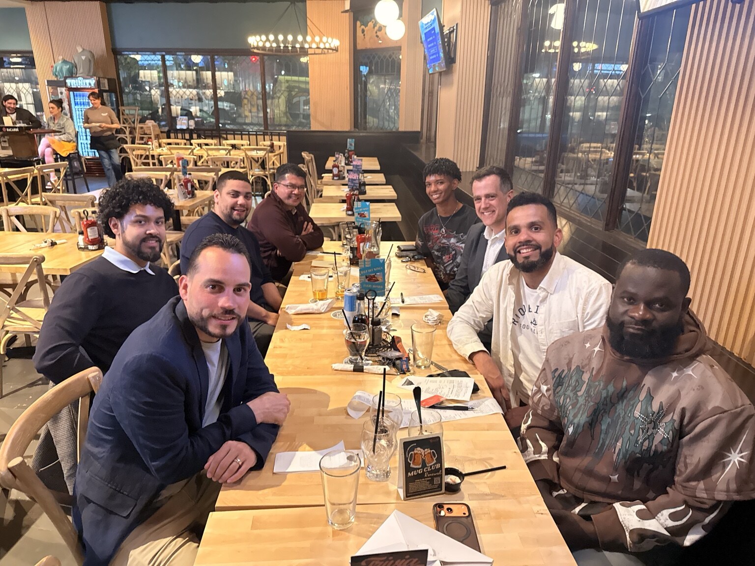 We Good participants gathered around a restaurant table for dinner and conversation.